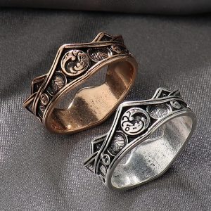 Dois anéis em formato de coroa com o dragão de três cabeças dos Targaryen, um bronze e outro prateado