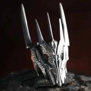 Anel em formato do elmo de espinhos de Sauron sobre pedra escura