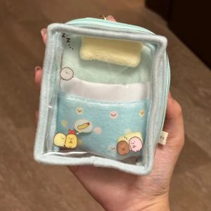 Mini bolsa azul transparente do Sumikko Gurashi em forma de caminha com travesseiro, segurada na mão