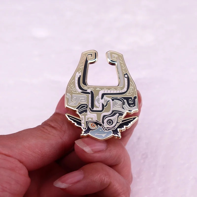Broche da Midna na palma da mão, para mostrar o tamanho