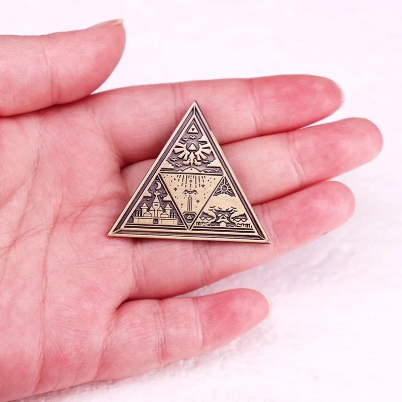 Broche da Triforce na mão, para mostrar o tamanho