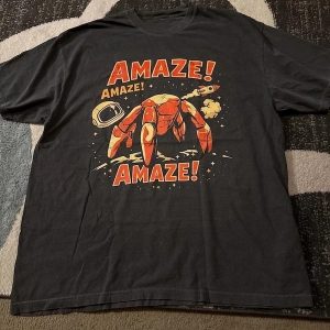 Camiseta escura com o Rocky de Project Hail Mary e a palavra Amaze em laranja