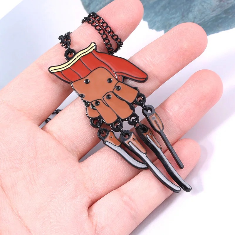 Pingente da luva do Freddy Krueger na palma da mão, com garras de metal prateado