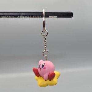 Chaveiro de figura do Kirby deitado na Estrela Dourada, preso a uma corrente com argola de metal