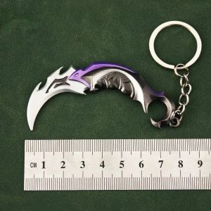 Chaveiro de metal em forma da karambit Reaver do Valorant, com argola, ao lado de uma régua que marca 9 cm