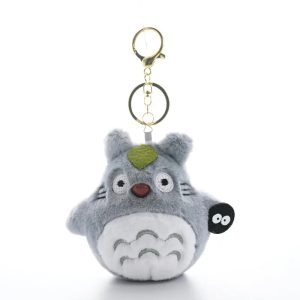 Totoro de pelúcia em formato de chaveiro, com folha verde e um Susuwatari preto, de Meu Amigo Totoro