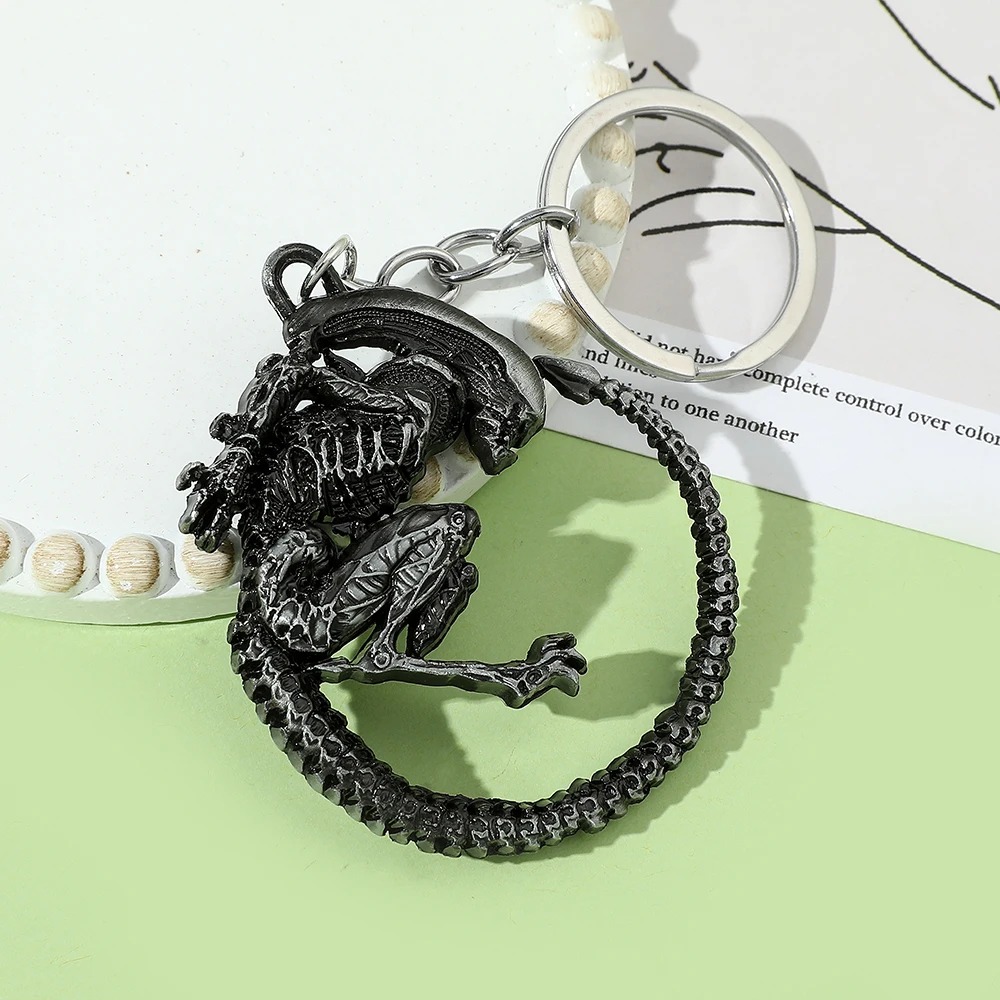 Chaveiro do Xenomorfo de Alien sobre fundo verde e branco, com cordão e argola