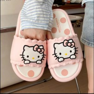 Par de chinelos slide rosa da Hello Kitty visto de cima, com sola de bolinhas