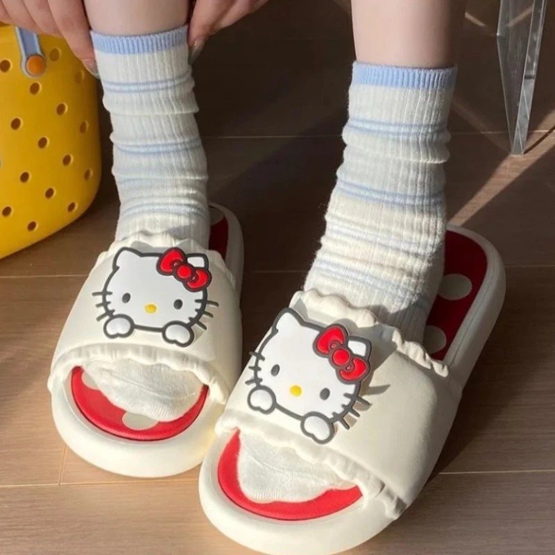 Pessoa calçando o chinelo creme da Hello Kitty, de sola vermelha com bolinhas