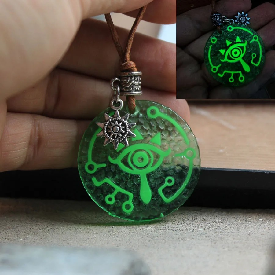 Colar do Olho Sheikah de Zelda em cordão marrom, com brilho verde no canto