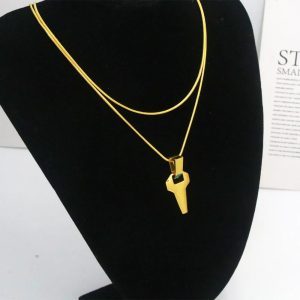 Colar dourado de duas camadas com pingente angular num busto de veludo preto, estilo David Martinez