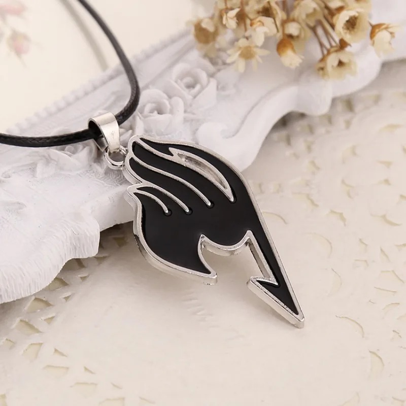 Pingente preto do emblema da guilda de Fairy Tail sobre renda