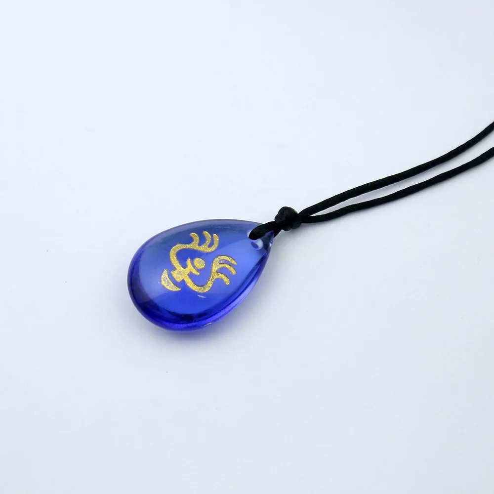 Close do pingente de vidro azul com símbolo dourado, do colar de O Castelo no Céu