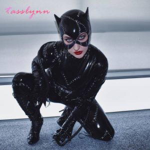 Modelo com o cosplay da Mulher-Gato, de The Batman: macacão preto brilhante e máscara
