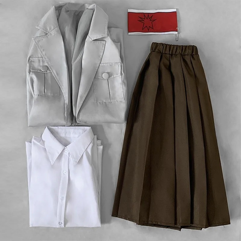 Peças do cosplay da Pieck, de Attack on Titan, dispostas na mesa: casaco, camisa, saia e braçadeira