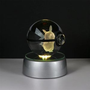 Esfera de cristal em formato de Pokébola com o Pikachu gravado em 3D, sobre base iluminada