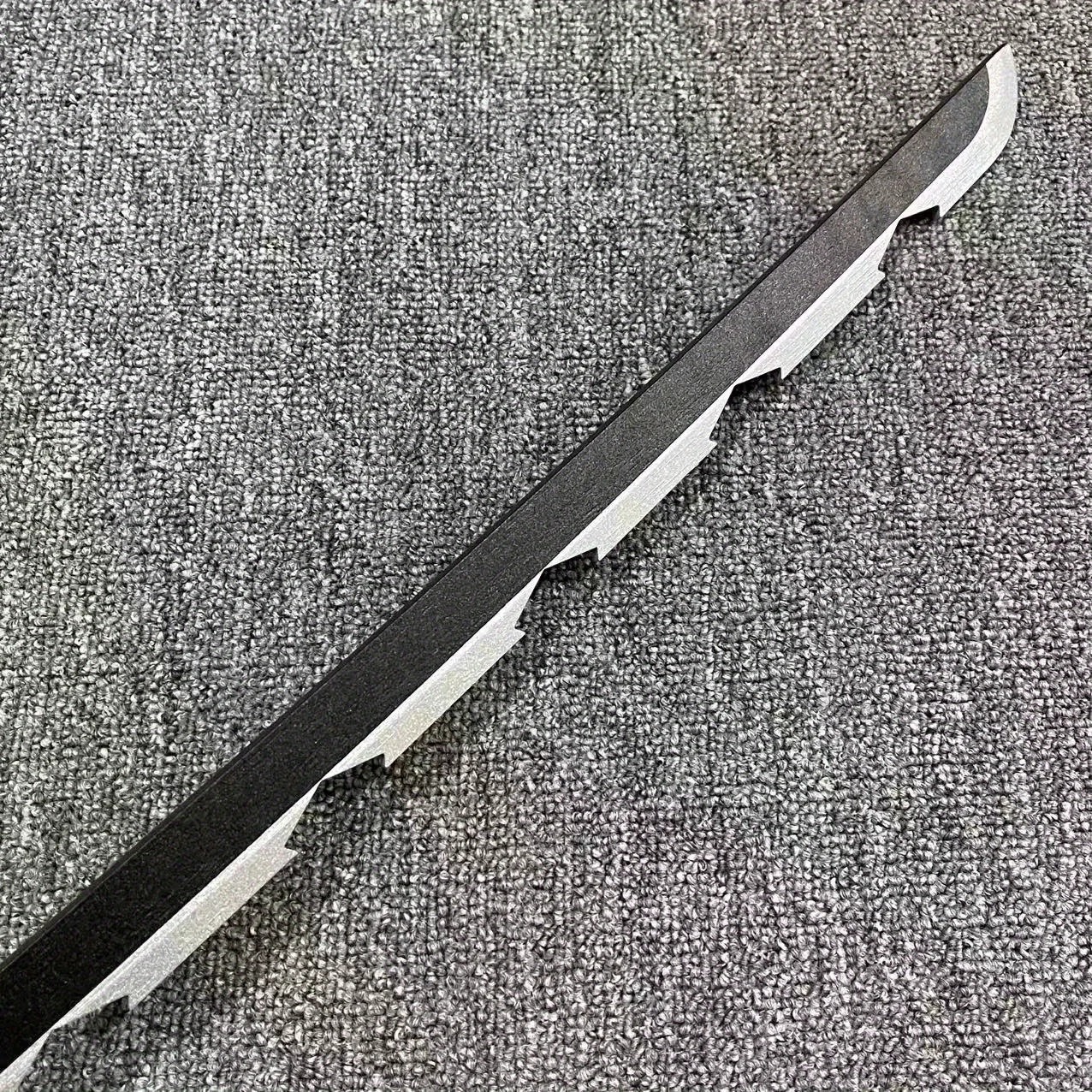 Detalhe da lâmina serrilhada de ABS da espada do Inosuke, de Demon Slayer