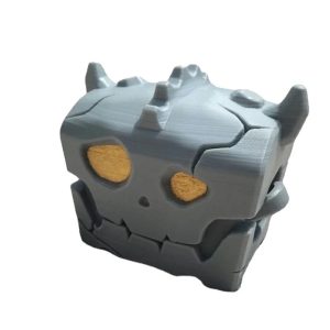 Estojo cinza em formato de baú monstro de Zelda, com rosto de caveira e olhos dourados