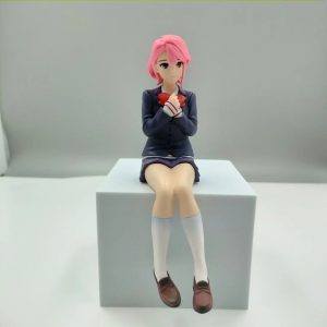 Aira Shiratori, de Dandadan, em figure sentada de uniforme escolar azul sobre um bloco branco