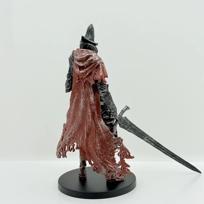 Costas da figure de cavaleiro estilo Elden Ring, com a capa vermelha rasgada e a espada