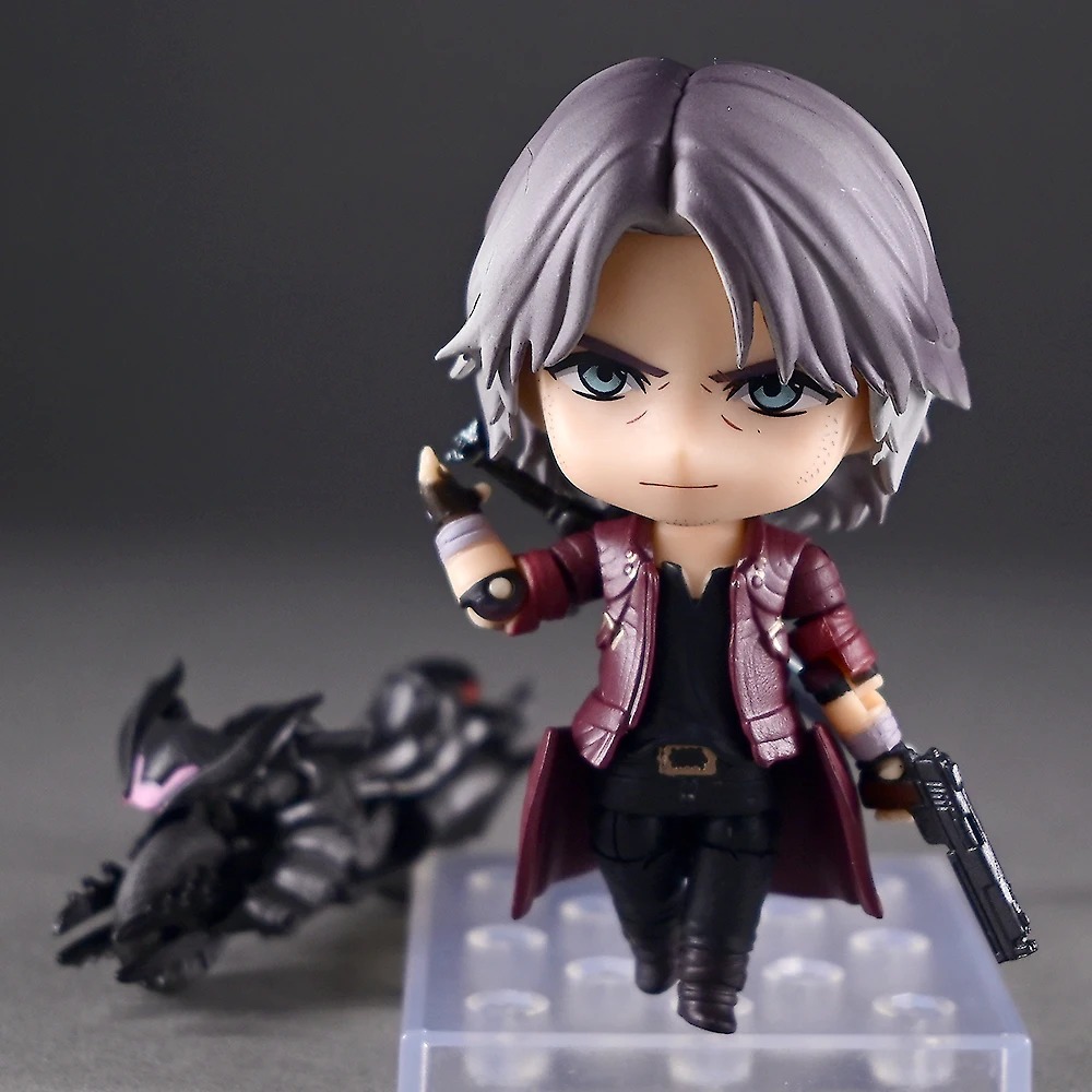 Dante em pose de ação com pistola, sobre a base transparente