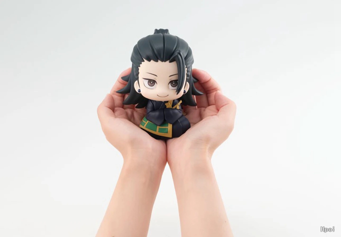 Mão segurando a figure chibi do Geto, de Jujutsu Kaisen, para mostrar o tamanho pequeno