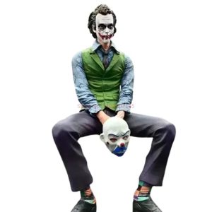 Coringa sentado de colete verde, segurando uma máscara de palhaço, figure de Batman: O Cavaleiro das Trevas