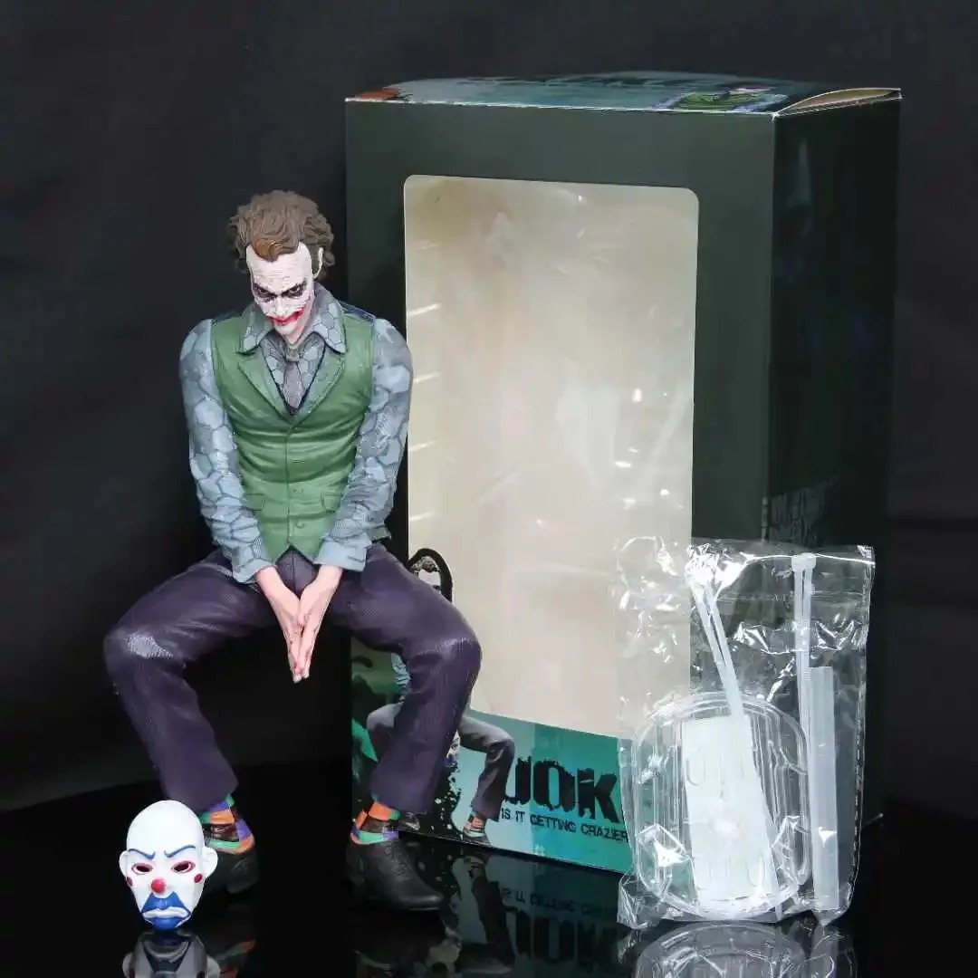 Coringa de Batman ao lado da caixa transparente e da máscara de palhaço