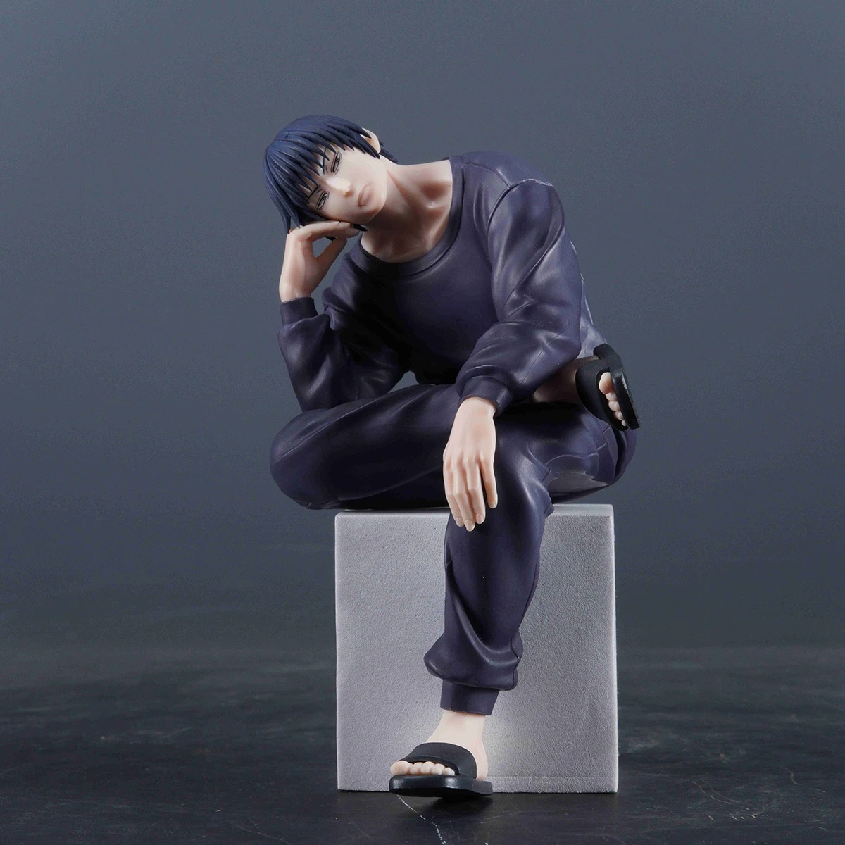 Figure do Toji sobre um bloco cinza, em pose sentada