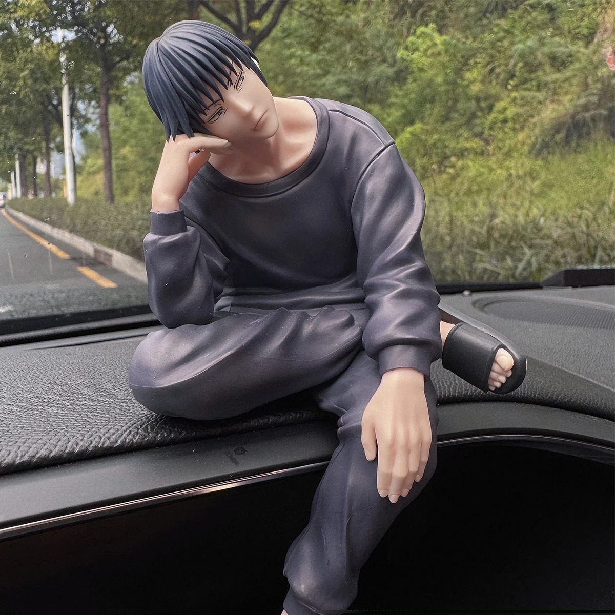 Figure do Toji no painel de um carro, em pose sentada