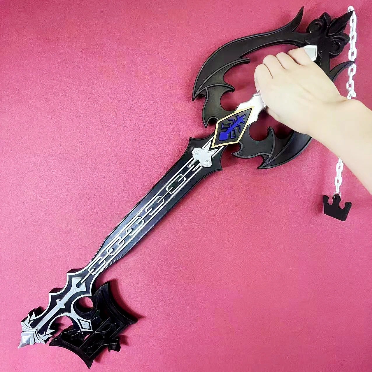 Keyblade Oblivion preta sobre fundo vermelho, réplica de cosplay do Sora em Kingdom Hearts