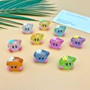 Dez miniaturas do Kirby em resina colorida e translúcida, num fundo amarelo, algumas com flor