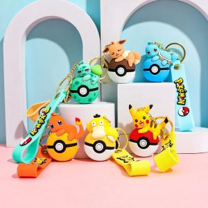 Seis chaveiros de Pokémon sobre Pokébolas com alças coloridas, cenário azul e rosa
