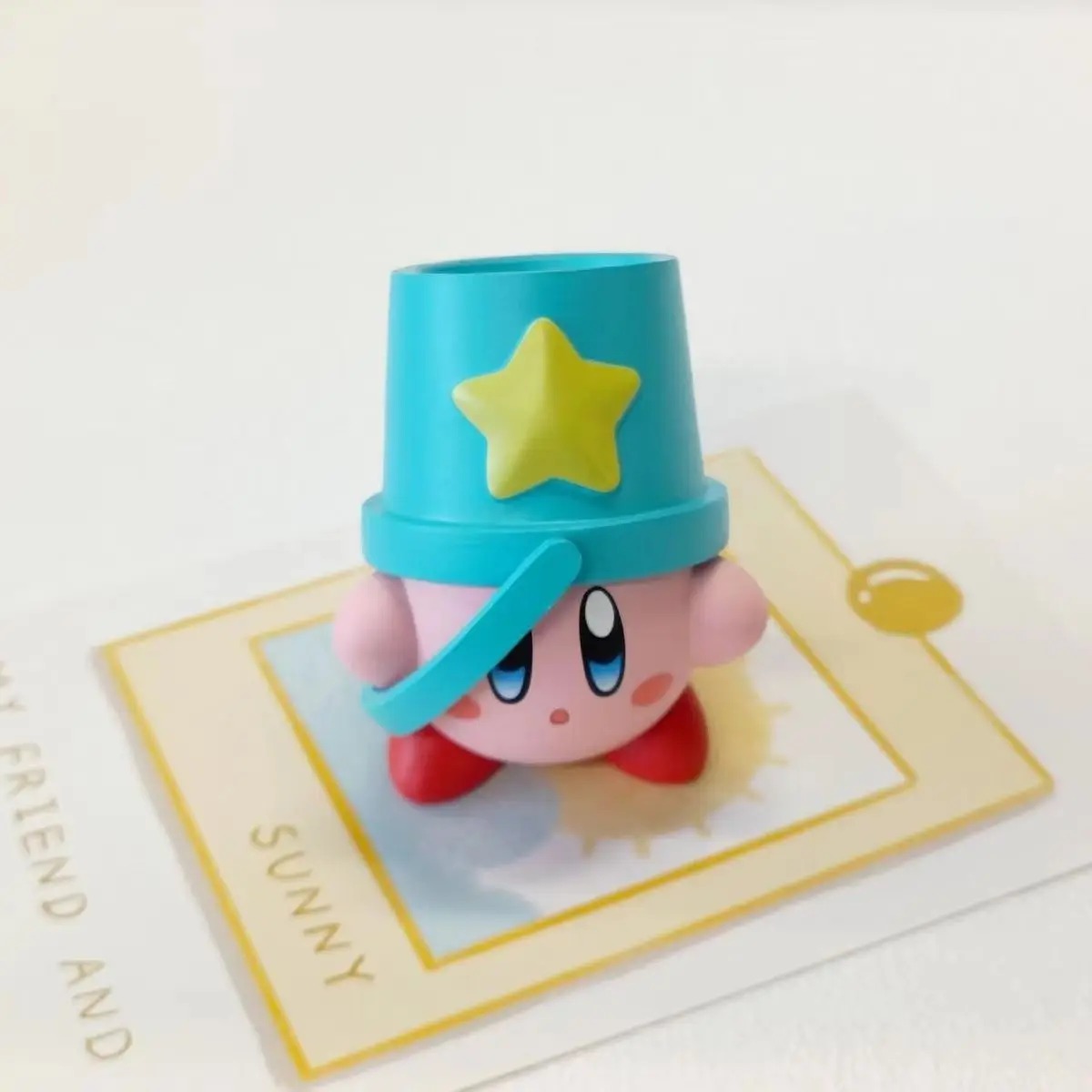 Kirby com um balde azul de estrela amarela na cabeça