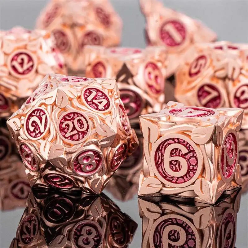 Dados poliédricos de metal rosé com números vermelhos, D20 e D6 em destaque