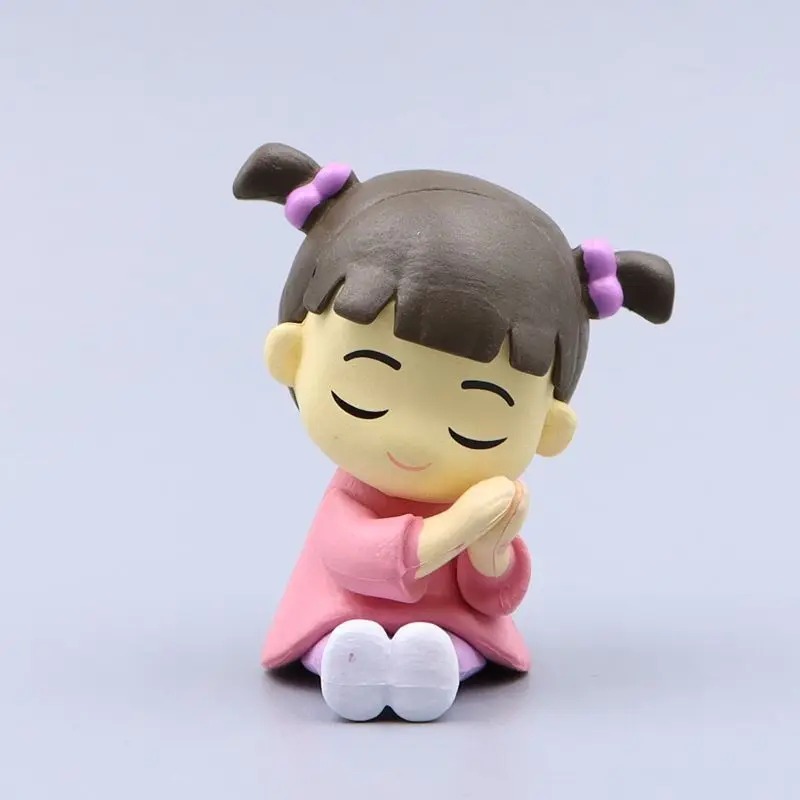 Boo em figure Q, de olhos fechados e mãos juntas, de Monstros S.A.