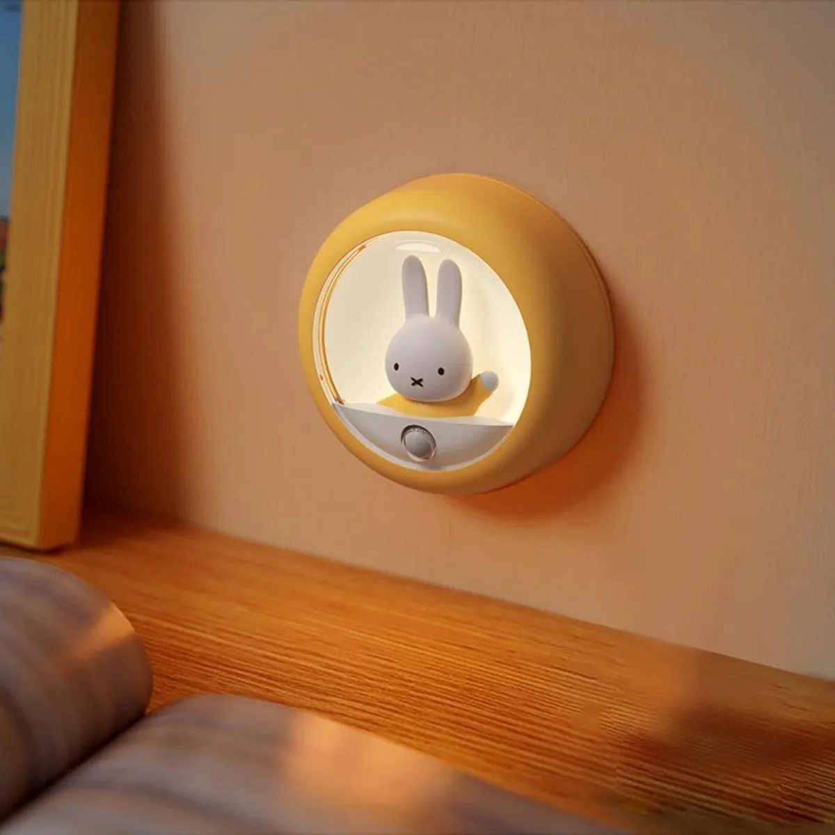 Luz noturna da Miffy acesa, instalada perto de uma estante de madeira