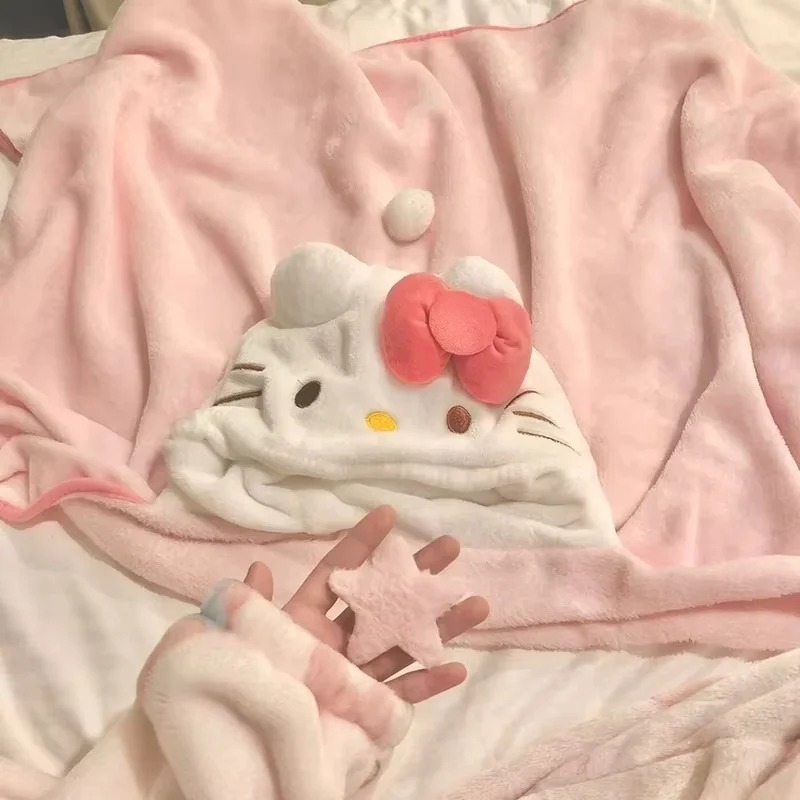 Manta rosa com capuz da Hello Kitty aberta sobre a cama, com rosto e laço rosa