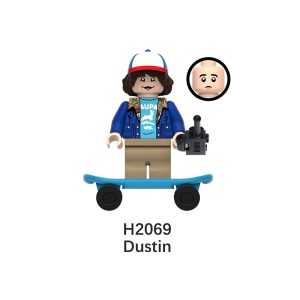 Mini figure de blocos do Dustin, de Stranger Things, de boné, camiseta azul e jaqueta jeans, com câmera e skate azul