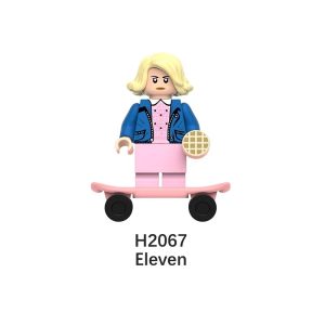 Mini figure de blocos da Eleven, de Stranger Things, loira, de jaqueta jeans e vestido rosa, com skate rosa