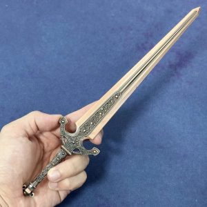 Miniatura da Ordovis's Greatsword, de Elden Ring, em metal, segurada na mão para mostrar o tamanho