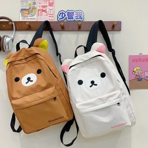 Mochilas do Rilakkuma, uma marrom e outra bege, penduradas num cabideiro, com rosto do urso e orelhinhas