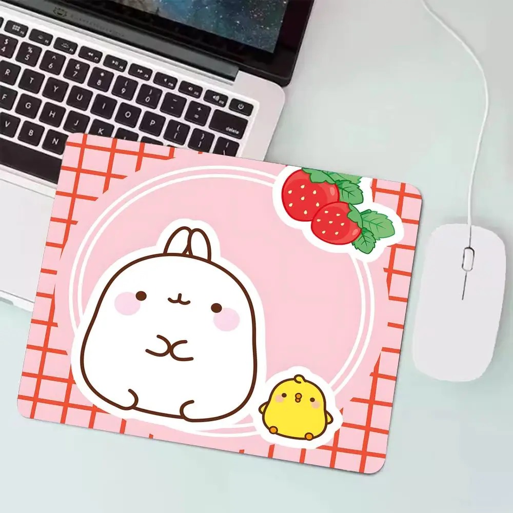Mousepad do Molang de fundo rosa quadriculado com morangos, ao lado de notebook e mouse