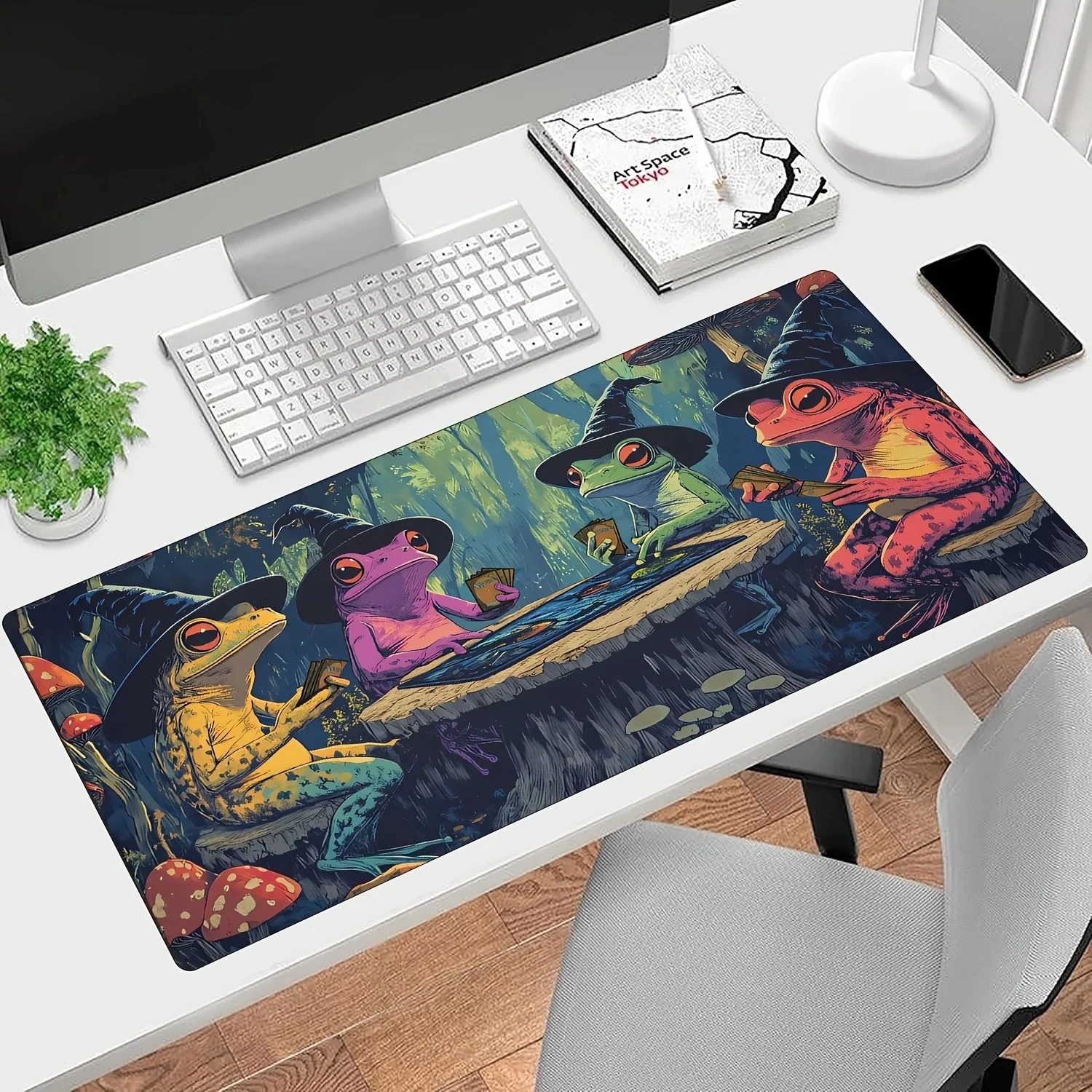 Mousepad grande dos sapos magos sobre escrivaninha branca com monitor e teclado