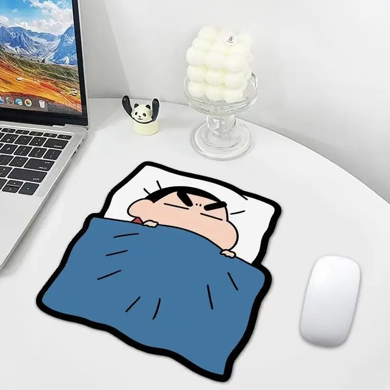 Mousepad do Shin-chan sobre a mesa, ao lado de um mouse branco e um notebook