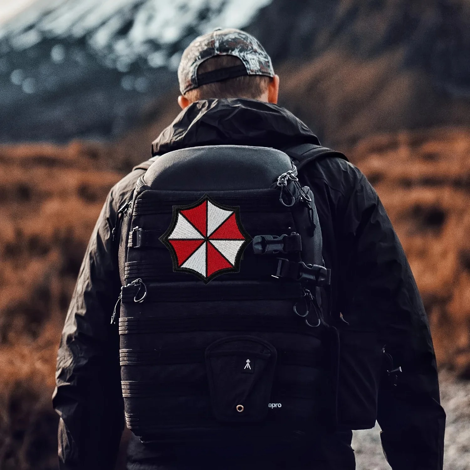 Patch Umbrella, de Resident Evil, preso em uma mochila tática preta
