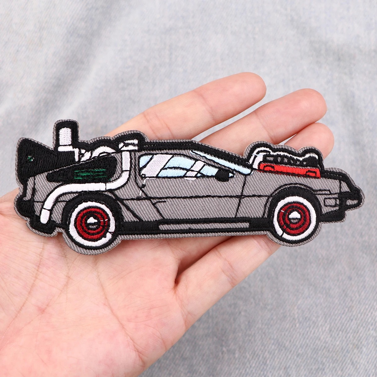 Patch do DeLorean, de De Volta para o Futuro, segurado na mão