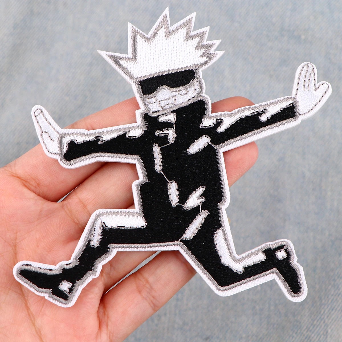 Patch do Gojo Satoru, de Jujutsu Kaisen, na palma da mão para mostrar o tamanho