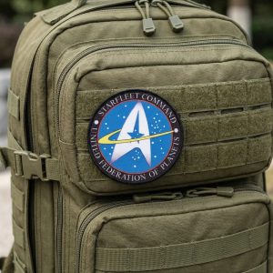 Patch redondo do Comando da Frota Estelar, de Star Trek, com seta dourada sobre azul, numa mochila verde