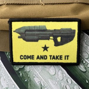 Patch amarelo de Halo com rifle de assalto e Come and Take It, preso numa mochila bege